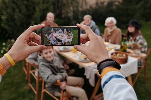 A smartphone records a multi-generational family enjoying an outdoor meal together.